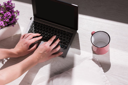 Modern blogger workplace. Female typing on laptop. Remote job in creative place top view, unrecognizable woman hands, black screen mockupの写真素材