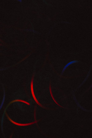 Abstract background of colorful lines in motion on black. Bokeh of defocused curves, blurred neon blue and red leds, festive or business backdrop of serpantine, holidays and celebrationsの写真素材