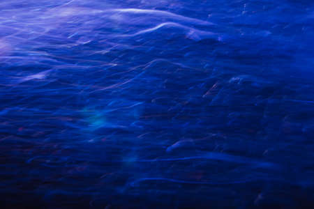 Abstract background of blurred lines in motion similar to blue water surface. Backdrop of clear sea depth, shimmering and glare lights of sunbeams, wallpaper of aqua conceptの写真素材