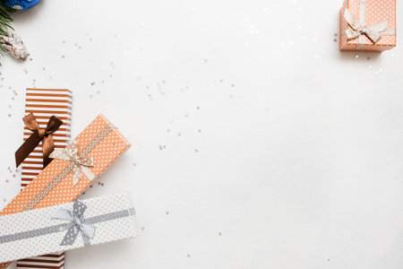 Festive background of Christmas presents. Gift boxes on white background with silver star tinsels top view. Holidays, New Year, festival and Christmassy conceptの写真素材