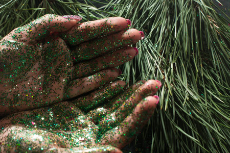 Festive backdrop for representing Christmas gift. Top view holiday sparkled open palms of woman on...