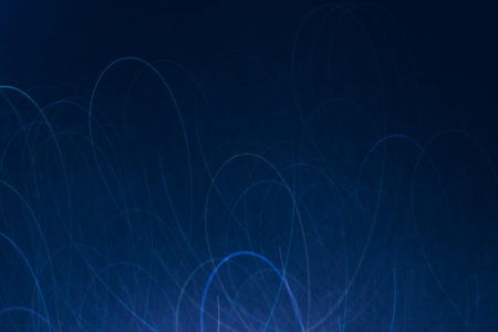 Abstract background of blue lines in motion on black wallpaper. Bokeh of defocused curves, blurred neon leds similar to skates mark on ice, backdrop of city lights and bannersの写真素材