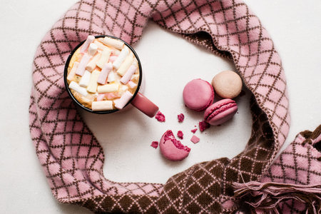 Concept of cold winter morning with latte and macaroons. Hot drink with marshmallow and colorful...