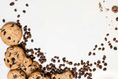 Wholegrain chocolate scone with coffee grains on white background, close up top view with free space in the middle. Delicious cookies and culinary art of coffeehouse conceptの写真素材