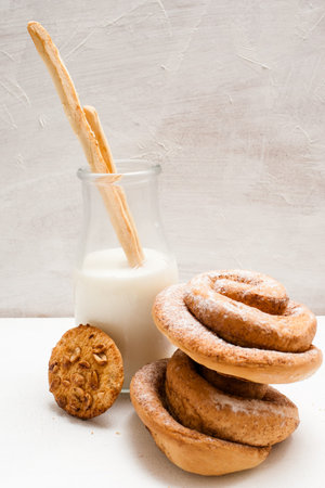 Composition of pastry products with milk close up. Wholegrain scone and baked rolls with bottles of lacto drink and breadstick in it. Concept of home-baked shopの写真素材