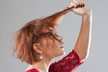 Bad day, hair loss . Hairstyle advertising. Changes in woman life, looking for new style. Young female on grey background, fashion conceptの写真素材