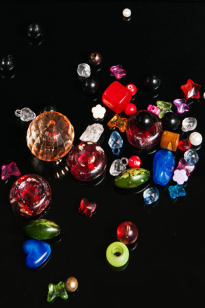 Colorful beads on black background, top view. Handmade child creativity and accessories design beadingの写真素材