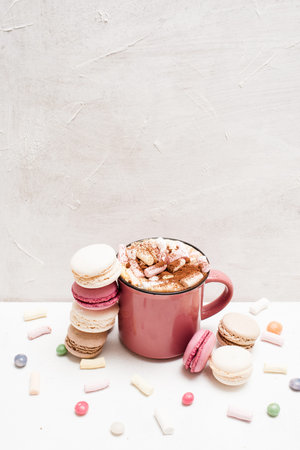 Culinary art of macaroons and latte on white backdrop, close up. Hot drink with delicious cakes, marshmallow and candies. Free space aboveの写真素材