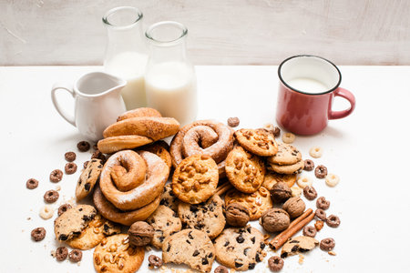 Assortment of products eating with milk. Pastry organic breakfast, close up. Wholegrain scones and baked rolls with bottles and cup of lacto drinkの写真素材