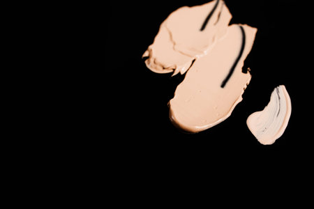Cosmetic liquid foundation shades swatch on black background, top view free space. Professional face make up product and concealer samplesの写真素材