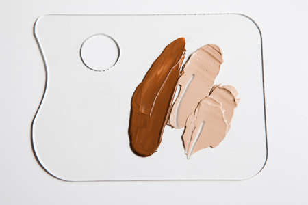 Cosmetic foundation different shades swatch on palette on white background, close up. Professional make up product for face and concealer samplesの写真素材