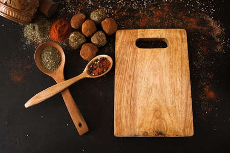 Spicy cheese assortment. Healthy rustic food with free space. Gourmet sorts of dairy with spices on black background, recipe and menu conceptの写真素材