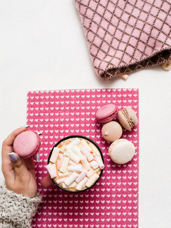 Sweet morning with latte and macaroons. Unrecognizable woman with colorful cakes and hot drink with marshmallow, top view. Love of desserts and sweets conceptの写真素材