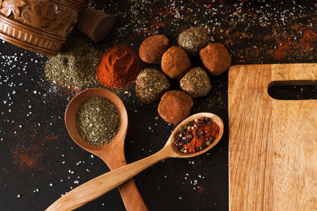 Spicy cheese assortment closeup. Healthy rustic food with free space. Gourmet sorts of dairy with spices on black background, recipe and menu conceptの写真素材