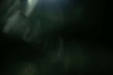 Real Lens flare light effect. Sparkle ray leak on black background. Optical effect of spotlight. Flash leak beam.の写真素材