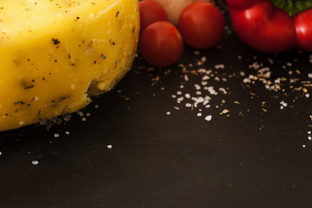 Food composition of gourmet cheese, close up free space. Quality sort of Caciotta with herbs and cherry tomato, upmarket conceptの写真素材