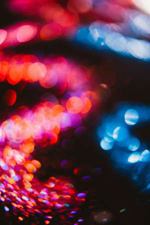 Abstract wavy sparkling glitter on contrast black background. Defocused bokeh conceptの写真素材