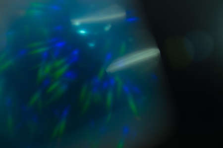 Real Lens flare light effect. Sparkle ray leak on black background. Optical effect of spotlight. Flash leak beam.の写真素材