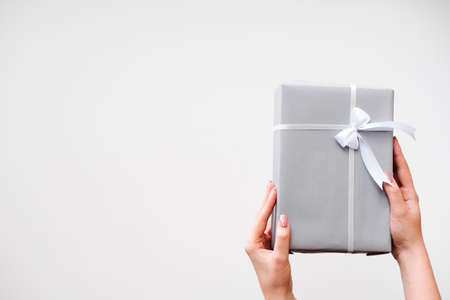 Woman hand holding gift box with birthday present on white backgroundの写真素材