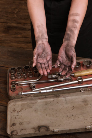 Female mechanic. Dirty woman hands and a set of tools. Professional girl will repair your car