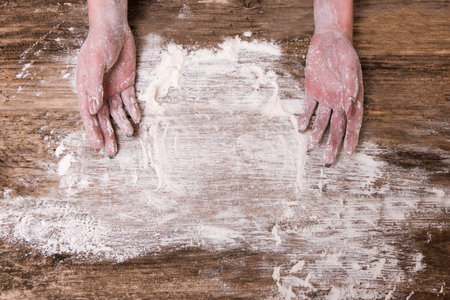 Housewife baking bread or a pie at her home kitchen. Hands covered in flour. Cooking for the familyの写真素材