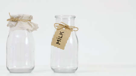 Empty glass milk bottles on white background. Dairy products concept.の写真素材