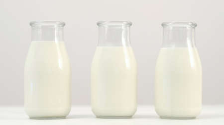 Three milk or yogurt bottles on white background. Selection of quality dairy products. Wide choice in shops. Copyspace conceptの写真素材