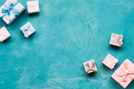 Blue and pink gift boxes on blue background top view. Present choosing for opposite genders. Boy and girl differenceの写真素材