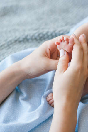 mother does a foot massage to a newborn baby. mother's care. healthy lifestyle.の写真素材