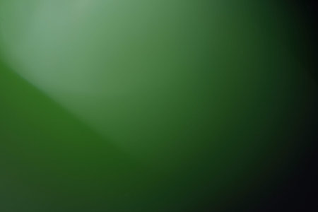 blurred glowing green light. lens flare. soft shine dark backgroundの写真素材