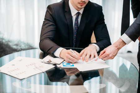company ceo signing documents. his assistant pointing where to put signature. casual working day of a corporate executiveの写真素材