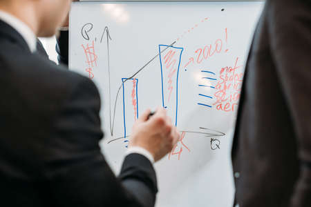 teamwork and cooperation. business men discussing a graph of company growth rates and thinking of new development strategies.の写真素材
