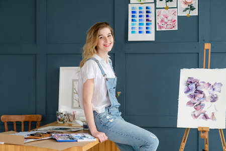 art painting hobby. creative leisure. girl sitting near a drawn picture. talent inspiration creation and self expression conceptの写真素材