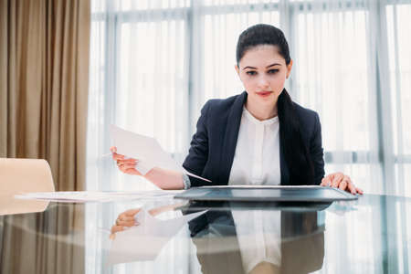 business lady at work. company manager. woman looking through documents in office. professional corporate dresscodeの写真素材