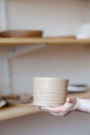 pottery workshop. artisan hand showing a craft clay jug. handmade crockery conceptの写真素材