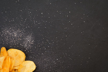 chips food background. wavy ridged potato crisps on dark background. salty spicy crunchy slices....