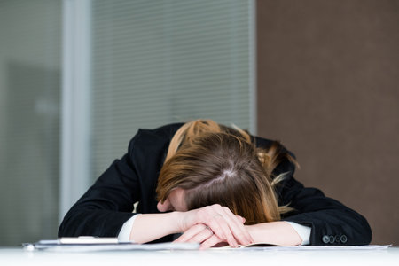 overworking fatigue workaholic. tired business woman laid her head on the office desk