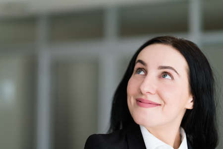 emotion face. happy smiling cheerful pleased woman looking up young beautiful brunette girl portraitの写真素材