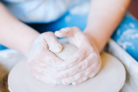 pottery handcraft hobby. hands forming and shaping a ball of clay on potter wheel