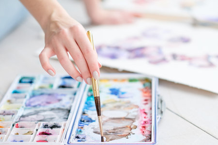 art painting classes. creative hobby and self expression. hand mixing watercolors with a brushの写真素材