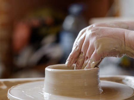 pottery handcraft hobby. hands forming and shaping clay on potter wheelの写真素材