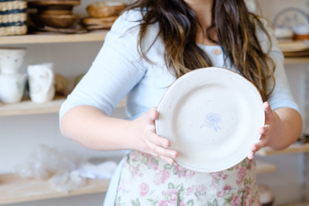 pottery workshop. artisan showing a clay plate. handmade crockery conceptの写真素材