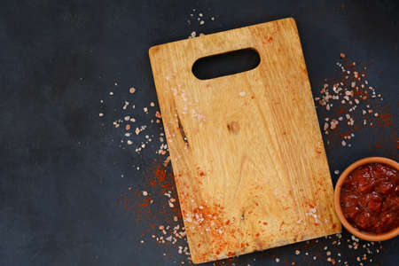 wooden cutting board and salsa sauce in a dipping dish. cooking and food preparing. copy space concept.の写真素材