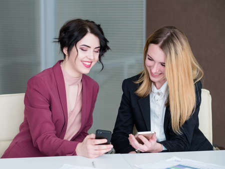 communication information sharing. business partners or colleagues discussing something on the mobile phone.の写真素材