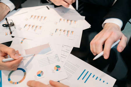 business paperwork. data analysis, marketing statistics research. office workers study documents with graphs and chartsの写真素材