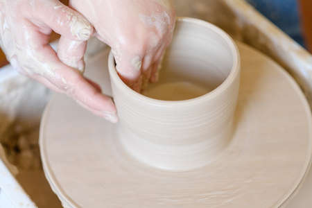 pottery workshop. handmade craft. artisan forming and shaping clay on potter wheelの写真素材