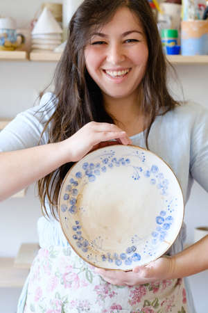 handmade hobby pottery courses. master class at workshop. potter holding craft clay crockery plateの写真素材