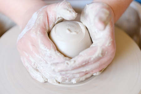 handmade hobby pottery courses. master class at workshop. potter forming clay on turning wheelの写真素材