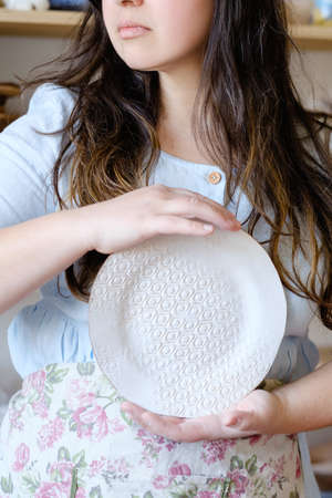 pottery handicraft skills. traditional art of creating ceramics. potter holding clay plate. craft crockery conceptの写真素材