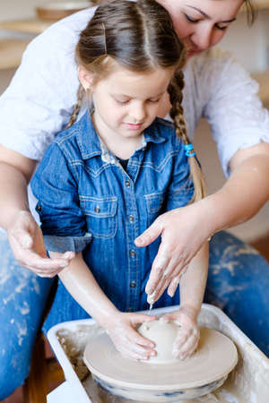 child hobby. creative pottery leisure. artistic kid upbringing. little girl working with clayの写真素材